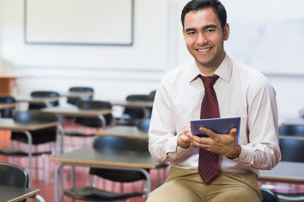 Portrait of a smiling teacher with tablet PC in the class room.jpeg